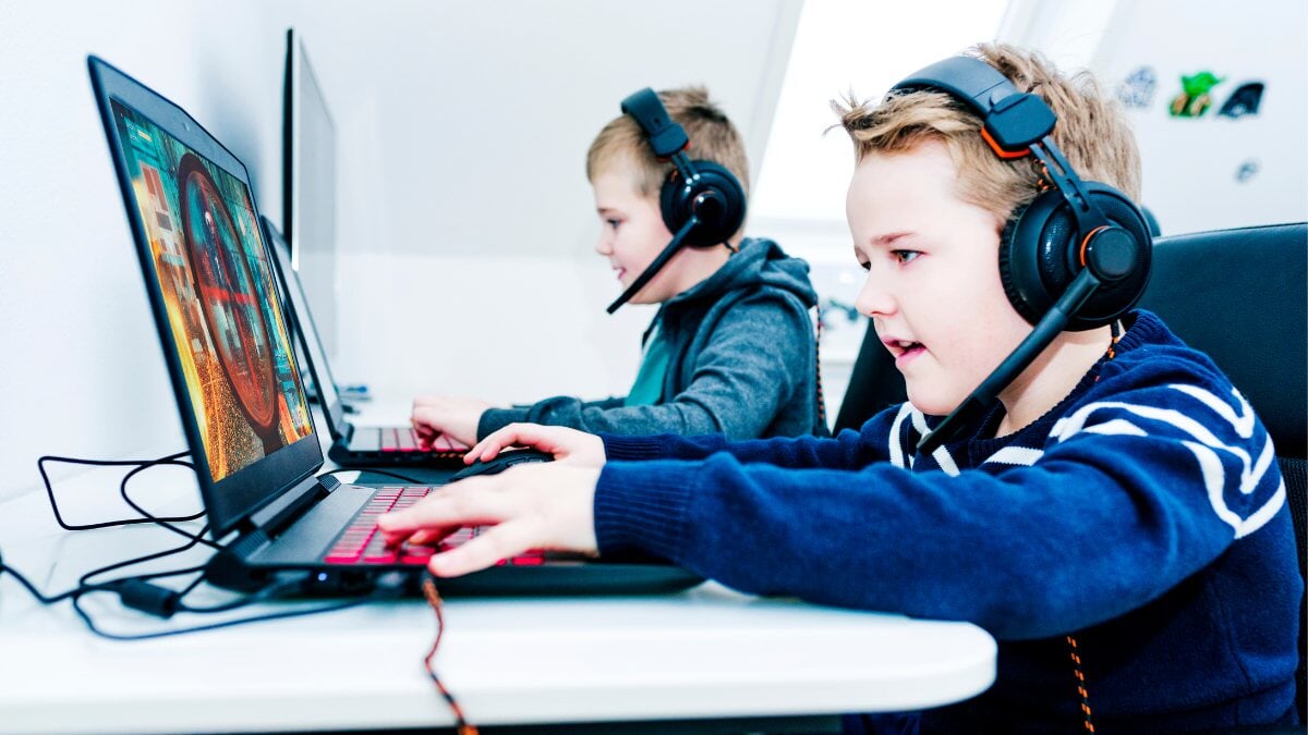 Les enfants jouent à des jeux vidéo avec des ordinateurs portables et des écouteurs de jeu