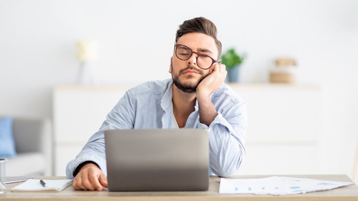 un jeune homme portant des lunettes horus x anti lumière bleue faisant une sieste à son bureau