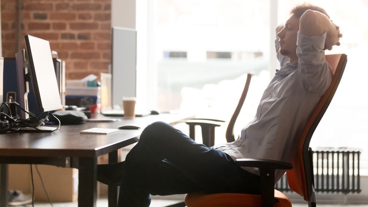 Un jeune homme d'affaires prenant une pause au travail se relaxant dans une chaise ergonomique