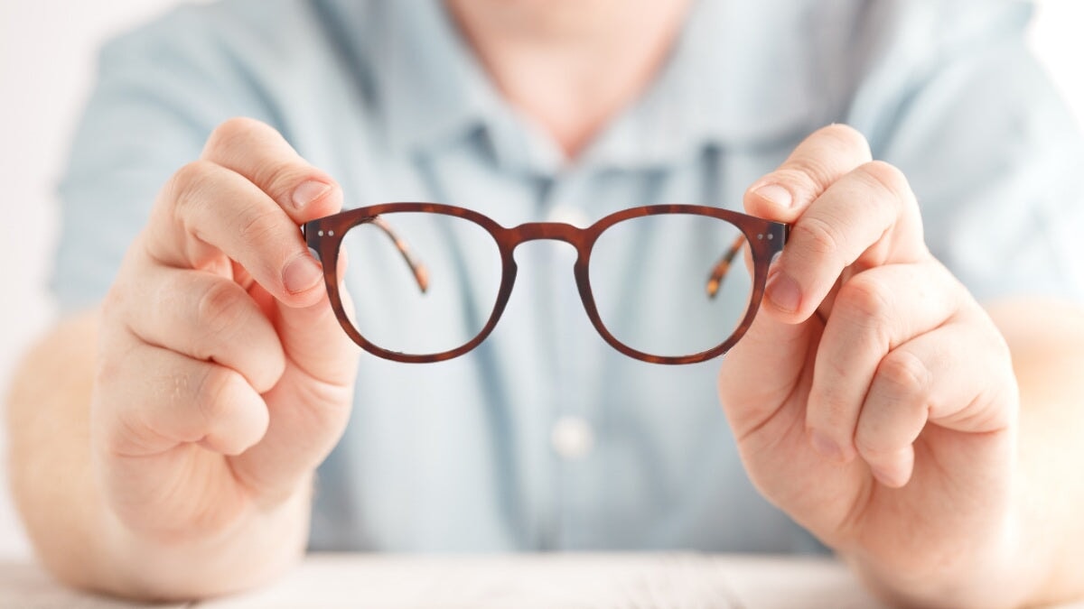 un homme tenant des lunettes Horus X