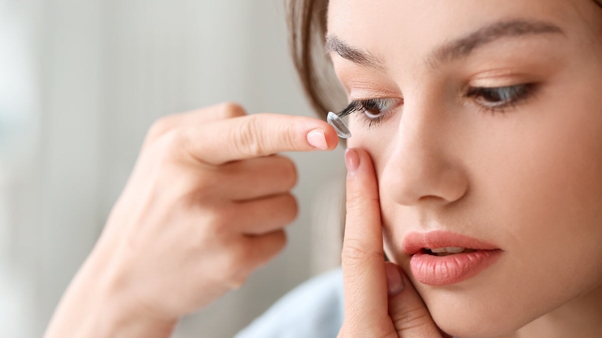 une femme mettant ses lentilles de contact dans ses yeux