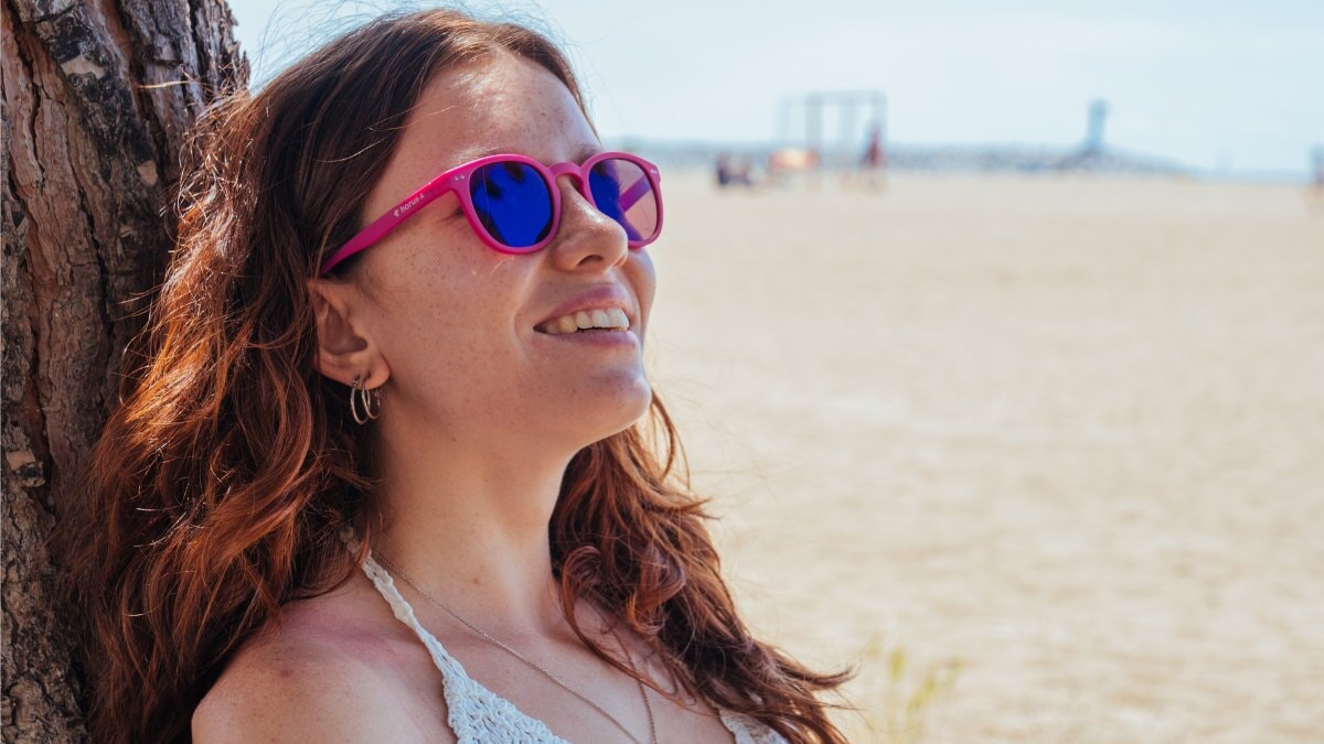 une jeune femme portant des lunettes de soleil Horus X à la plage