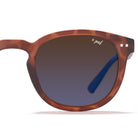 Lunettes de soleil retro Stockholm polarisées de couleur marron tortoise sur fond blanc, de face, zoom sur verre gauche avec logo x-pol